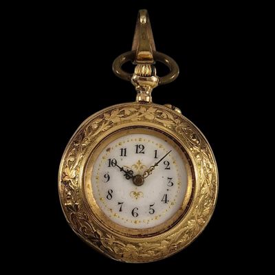 une montre de poche en or avec un cadran blanc sur fond noir