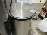 a large metal pot sitting on the floor in a kitchen