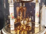 a clock that is under a glass dome on a table