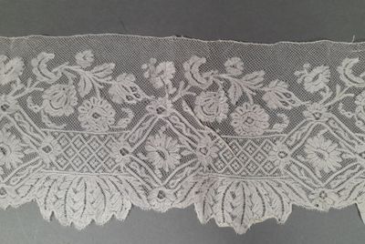 une image représentant une dentelle blanche ornée de fleurs et de feuilles