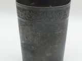 a black cup that is sitting on a white surface