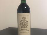une bouteille de vin posée sur une table à côté d'un mur