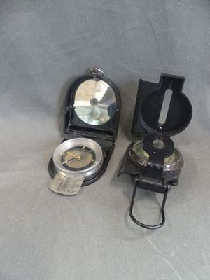 two different types of compasss on a gray surface