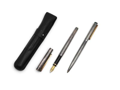 a set of three pens and a pen case sitting on top of a white surface