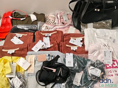 beaucoup de vêtements et de sacs posés sur un lit