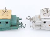 two toy trains sitting next to each other on a white surface