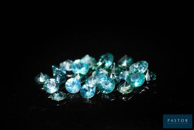 un gros plan sur un bouquet de diamants bleus posés sur une surface noire