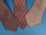 three different colored ties on a blue surface with a blue background