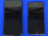 deux iPhones noirs posés l'un à côté de l'autre sur une surface bleue