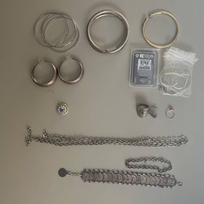 a lot of silver jewelry on the table