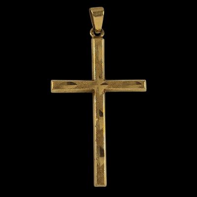 un pendentif en forme de croix en or sur fond noir