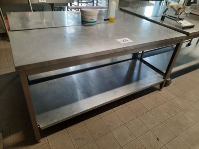 a large stainless steel table in the middle of a kitchen