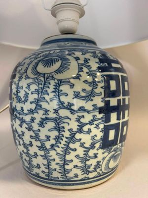 une lampe bleue et blanche munie d'un abat-jour blanc