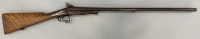 un vieux pistolet accroché au mur, muni d'une crosse en bois