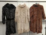 three coats hanging on a rack in a room