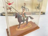a figurine of a man riding a horse in a glass case