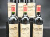 six bouteilles de vin rouge sont alignées