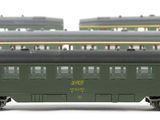 many green train cars that are lined up on the tracks