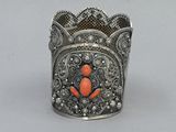 an old silver and coral colored cuff bracelet with a flower design