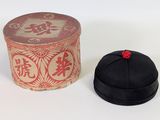 a black hat sitting next to a red box