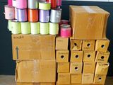 many rolls of thread on top of boxes on the floor