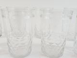 six glasses sitting next to each other on a white surface