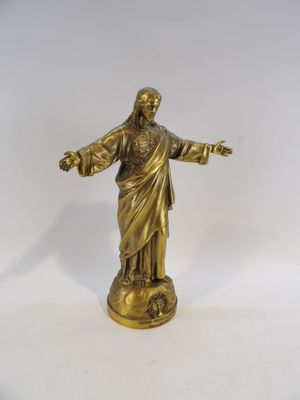 statue en laiton représentant Jésus tenant la croix, sur fond blanc