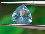 une topaze bleue tenue par une pince