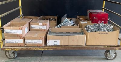 de nombreuses boîtes de vis sur un chariot dans un entrepôt