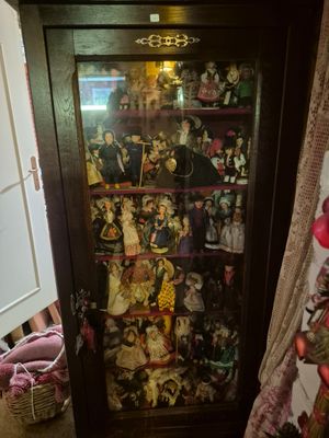 a cabinet with a lot of dolls in it