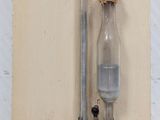a glass bottle hanging on the wall with a cork stopper