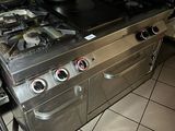 une cuisinière sur laquelle est posée une marmite dans une cuisine