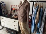 a mannequin in front of a rack of clothes