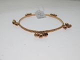 gros plan d'un bracelet en or sur une surface blanche