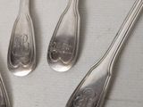 four spoons with a design on them are arranged in a circle