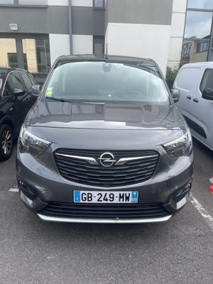the front of a grey opel parked in a parking lot next to other cars
