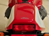 a close up of a red motorcycle parked in a garage
