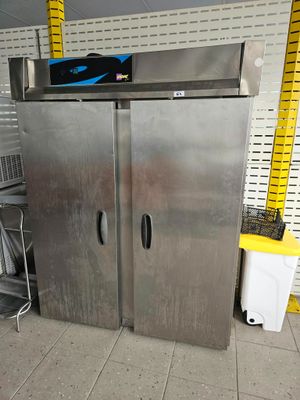 deux réfrigérateurs en acier inoxydable dans un magasin aux étagères jaunes