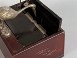 a silver bird sitting on top of a wooden box