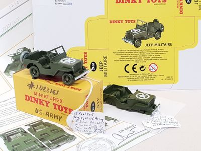 a toy army jeep and a toy army car on a table