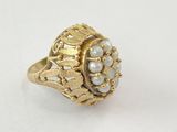 Gros plan sur une bague en or ornée de perles