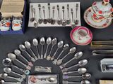 a lot of silver spoons and other silverware on a table