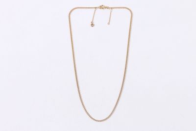 un ensemble composé d'un collier et de boucles d'oreilles en or sur fond blanc