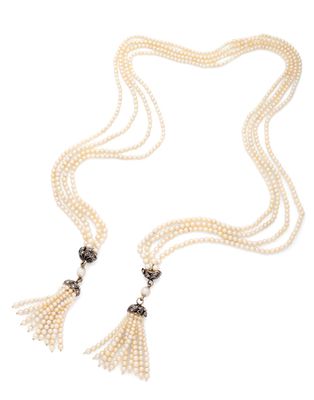 un collier de perles blanches et de diamants orné de pompons, sur fond blanc