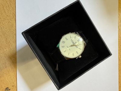 une boîte noire contenant une montre blanche