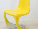 a yellow chair in a white room with a white wall