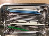 many different tools in a metal container on a table