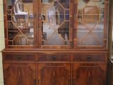 un vaisselier en bois avec des portes vitrées et un tapis