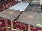 Des tables et des chaises sont alignées dans une pièce recouverte d'un tapis rouge
