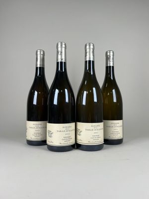 quatre bouteilles de vin sont alignées sur une table